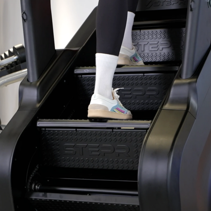 Person using a stair stepper machine in a gym setting