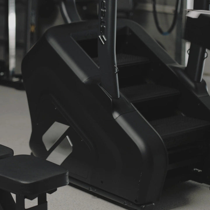 Close-up of a black exercise machine in a gym setting